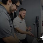 7tech vs Uprite Services for San Antonio IT Support Two 7tech technicians reviewing a workstation setup together at the company's San Antonio office.