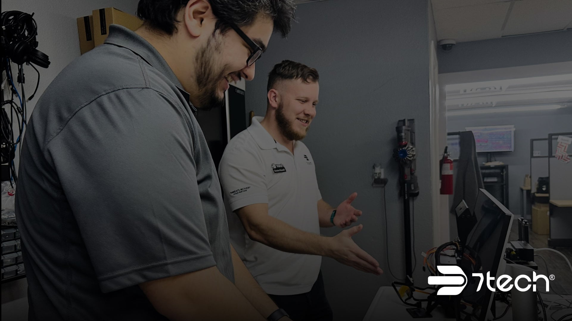 Two 7tech technicians reviewing a workstation setup together at the company's San Antonio office.