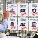 6 Manufacturing Cybersecurity Myths That Put Your Business at Risk Manufacturing cybersecurity myths reviewed in an office.
